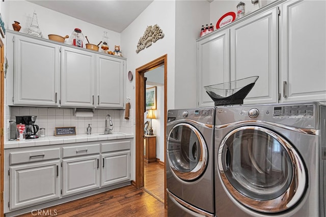 laundry area with cabinets, sink, independent washer and dryer, and dark hardwood / wood-style flooring