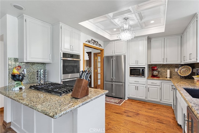 kitchen featuring white cabinets, stainless steel appliances, and light wood-type flooring