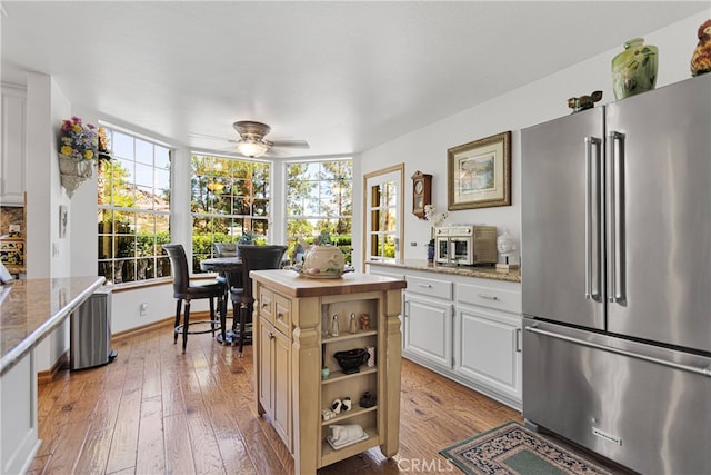 kitchen featuring ceiling fan, light hardwood / wood-style flooring, high end refrigerator, and a wealth of natural light