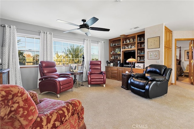 carpeted living room with ceiling fan