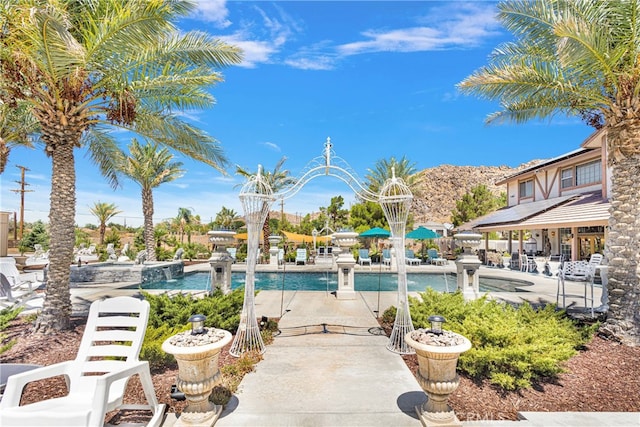 view of pool featuring pool water feature and a patio