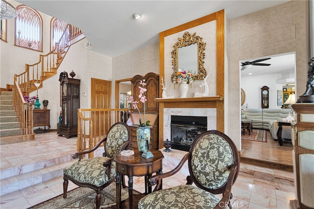 living room with a tile fireplace, ceiling fan, and a wealth of natural light