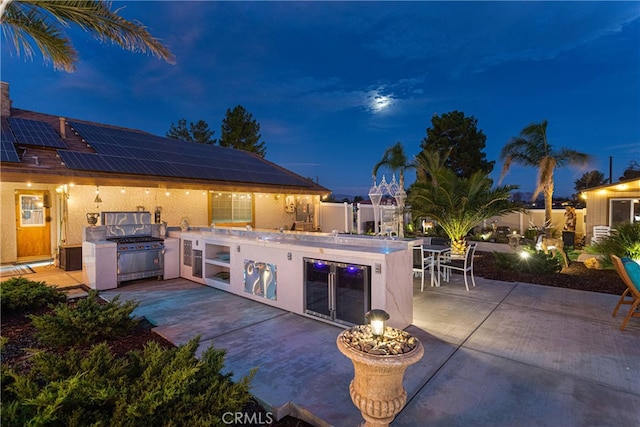 patio at twilight with an outdoor kitchen