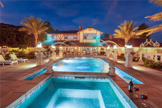 view of pool featuring pool water feature, an in ground hot tub, and a patio area