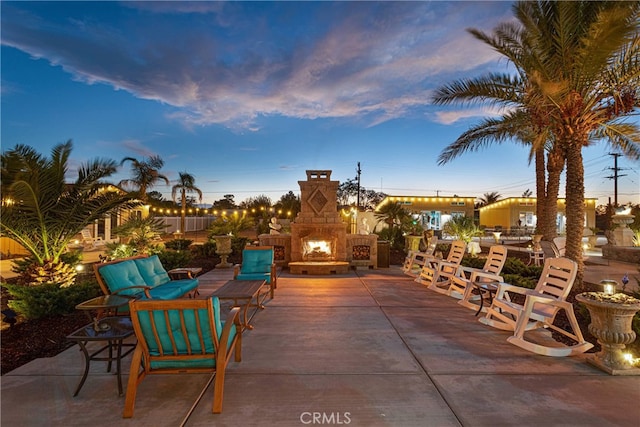 patio terrace at dusk with an outdoor stone fireplace