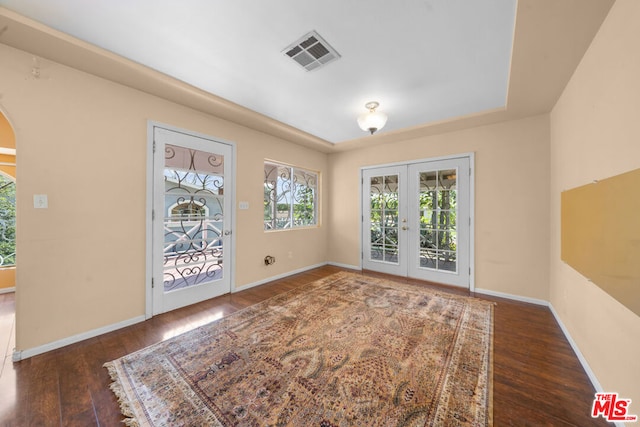 empty room with french doors and dark wood-type flooring