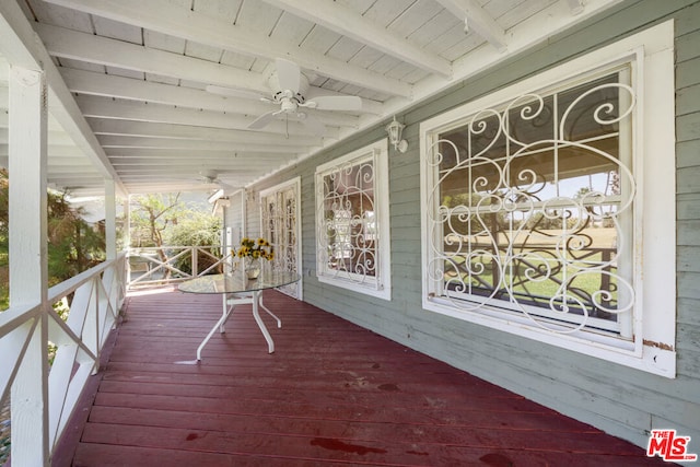 wooden terrace featuring ceiling fan and a porch