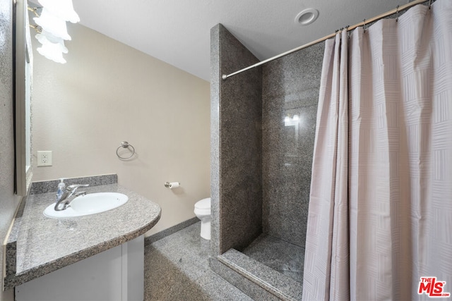 bathroom featuring a shower with shower curtain, vanity, and toilet