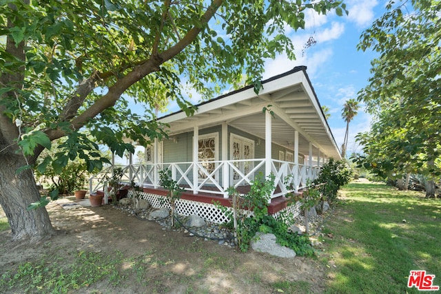 exterior space with a porch and a front yard