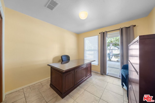 home office with light tile patterned floors and a textured ceiling