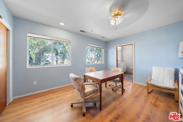 home office with light hardwood / wood-style floors and ceiling fan