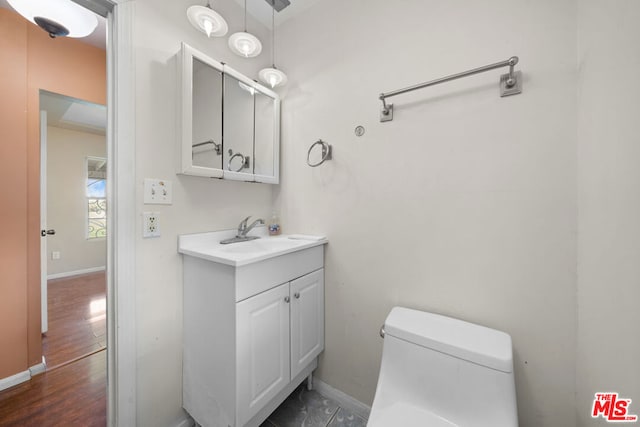 bathroom featuring toilet, vanity, and hardwood / wood-style flooring