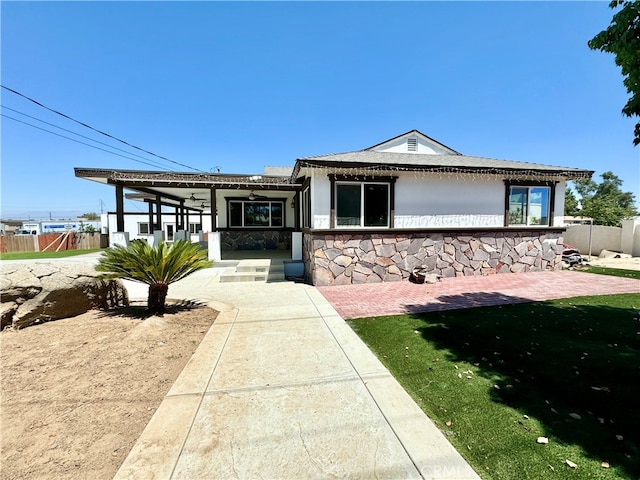 view of front facade featuring ceiling fan and a front yard