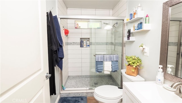 bathroom featuring tile patterned floors, a shower with door, vanity, and toilet