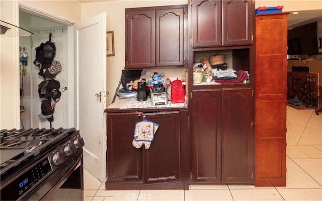 kitchen featuring black gas range oven and light tile patterned floors