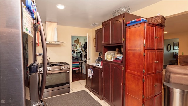 kitchen featuring stainless steel gas stove, wall chimney exhaust hood, and light tile patterned floors