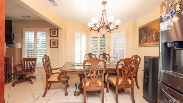 dining space with light tile patterned flooring and a chandelier