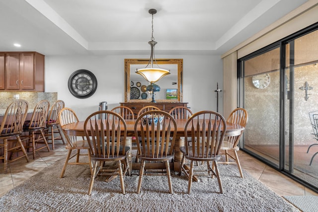 tiled dining area featuring a tray ceiling