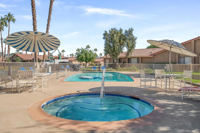 view of swimming pool with a community hot tub and a patio area