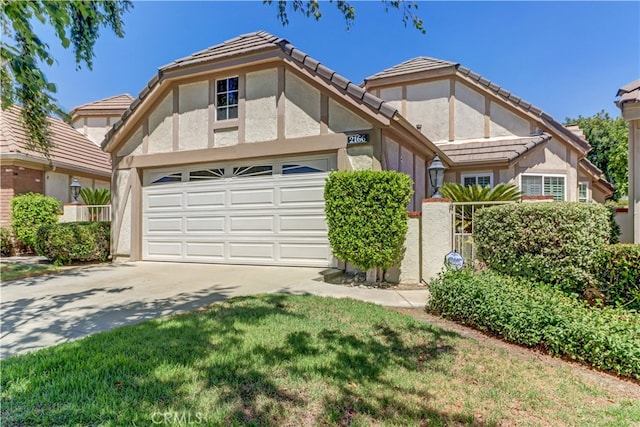 tudor home with a front yard and a garage