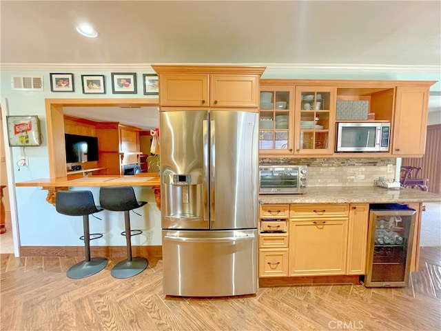 kitchen with crown molding, appliances with stainless steel finishes, tasteful backsplash, beverage cooler, and light stone counters