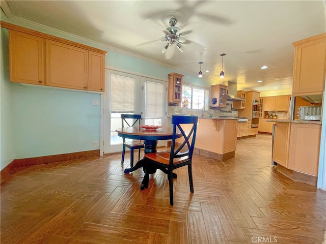 dining area with ceiling fan, ornamental molding, sink, and light parquet floors