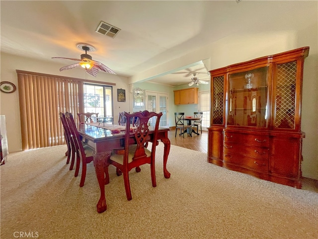 dining space with light colored carpet and ceiling fan