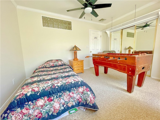 carpeted bedroom featuring crown molding, a closet, and ceiling fan