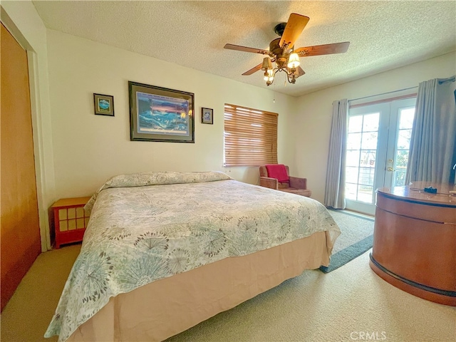 bedroom with a textured ceiling, access to exterior, light colored carpet, and ceiling fan