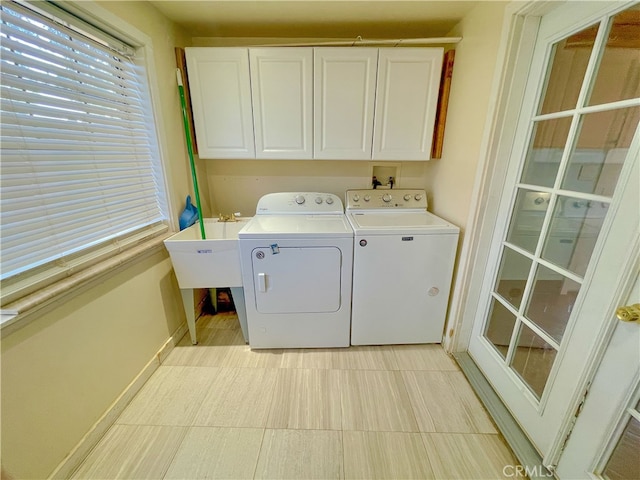 laundry area with sink, washer and dryer, and cabinets