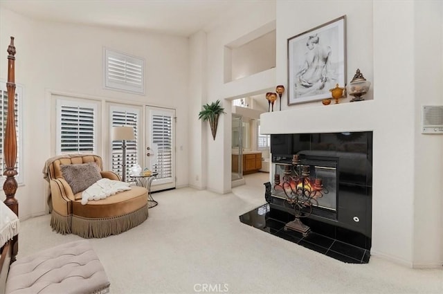 carpeted living room with a wood stove, high vaulted ceiling, and a healthy amount of sunlight