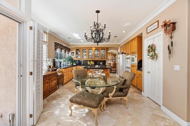 dining area featuring an inviting chandelier, ornamental molding, and sink