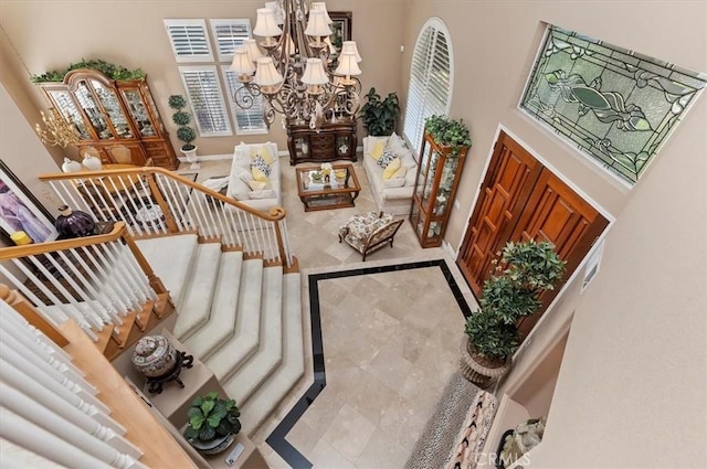 stairway featuring a towering ceiling and a chandelier