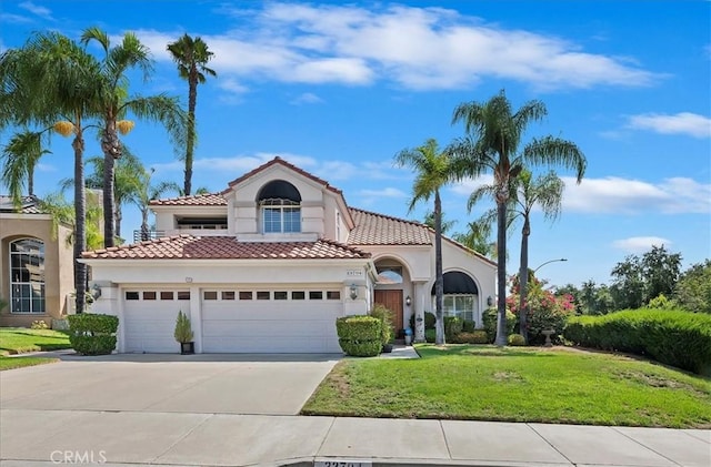 mediterranean / spanish home with a front yard and a garage