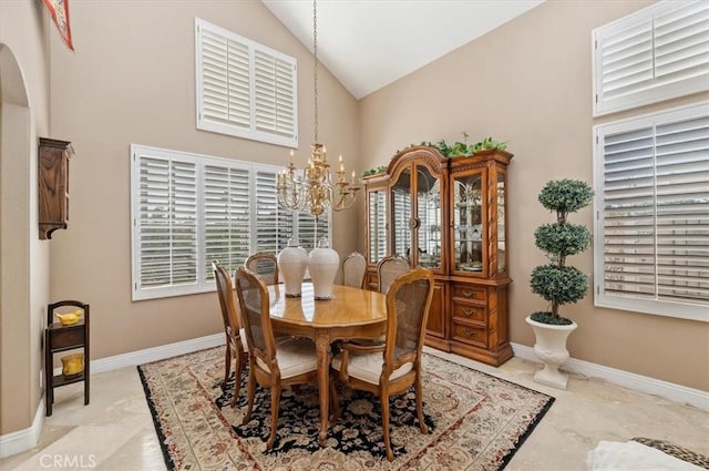 dining area with plenty of natural light, high vaulted ceiling, and a chandelier