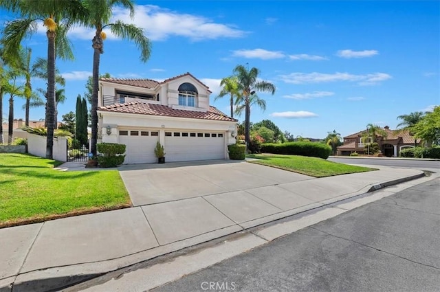 mediterranean / spanish house featuring a front lawn and a garage