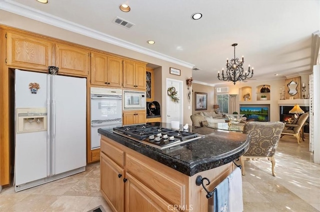 kitchen featuring white appliances, crown molding, pendant lighting, a notable chandelier, and a center island