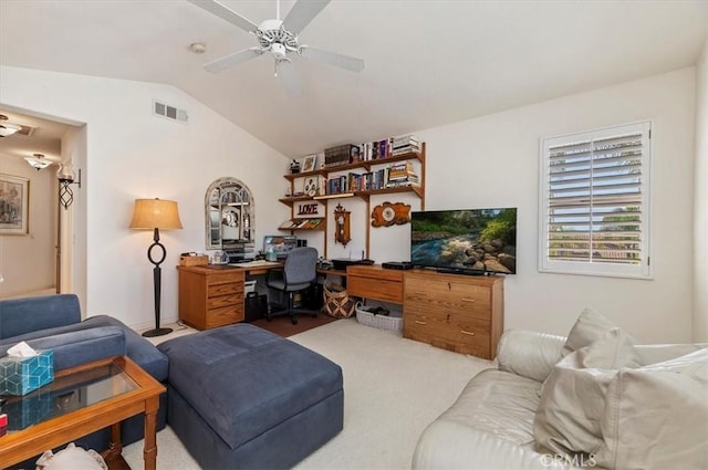 carpeted living room with ceiling fan and vaulted ceiling