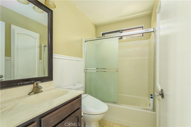 full bathroom featuring tile patterned floors, toilet, vanity, and bath / shower combo with glass door