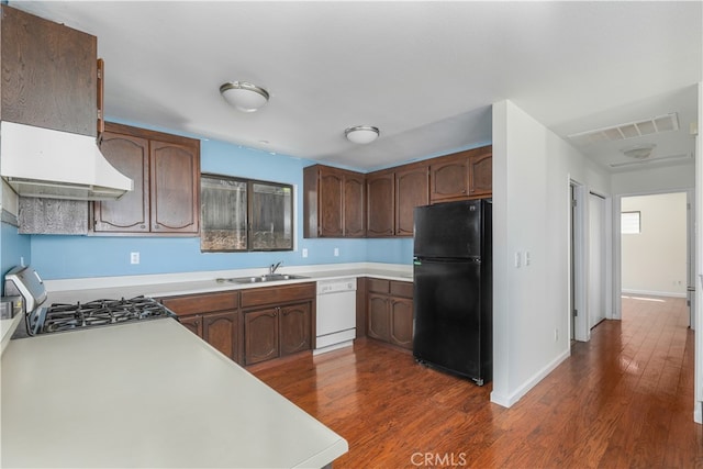 kitchen featuring dark brown cabinetry, white dishwasher, stainless steel range, black refrigerator, and dark hardwood / wood-style flooring