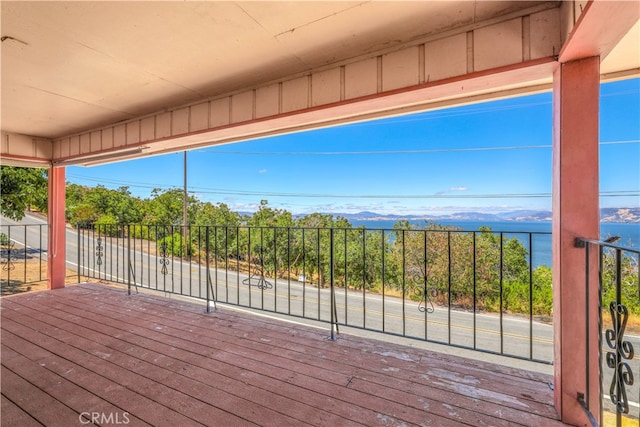 wooden terrace featuring a water and mountain view