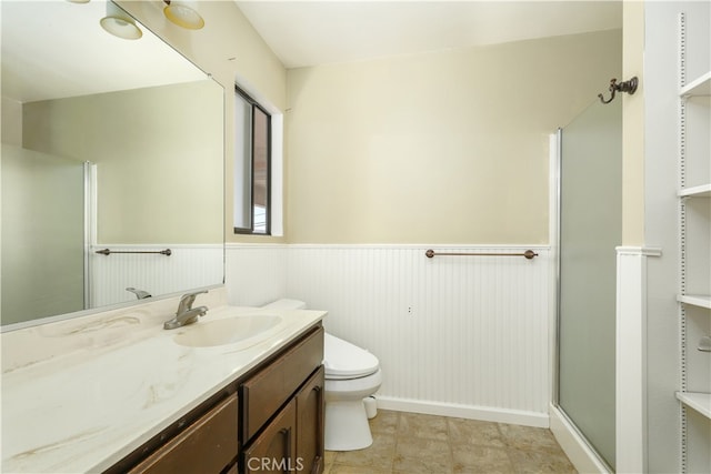 bathroom featuring vanity, toilet, and a shower with door