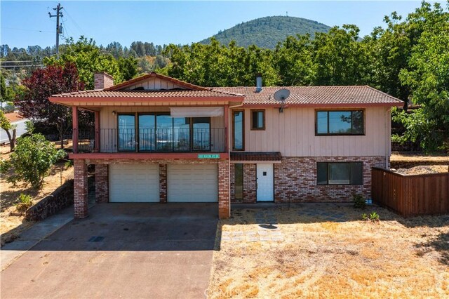 view of front of home featuring a balcony, a garage, and a mountain view