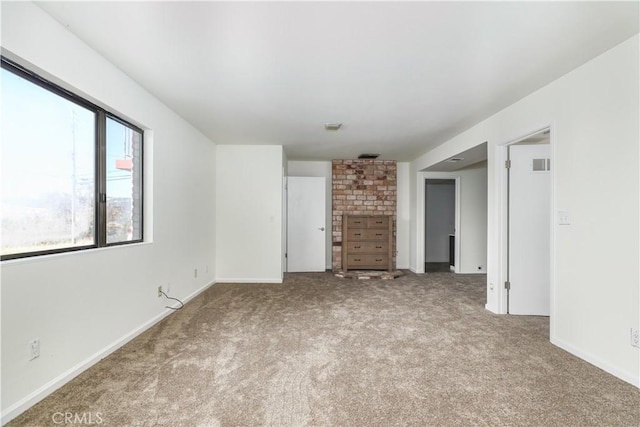 empty room with baseboards, visible vents, and carpet flooring