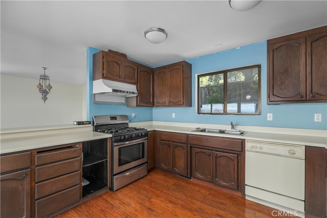 kitchen with dishwasher, gas range, light countertops, under cabinet range hood, and a sink