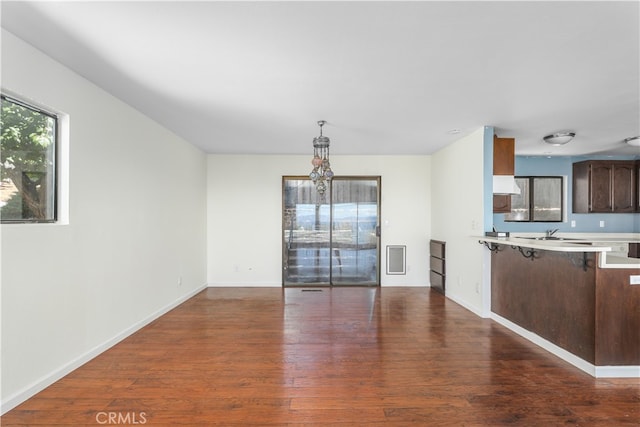 unfurnished living room with dark hardwood / wood-style flooring and sink