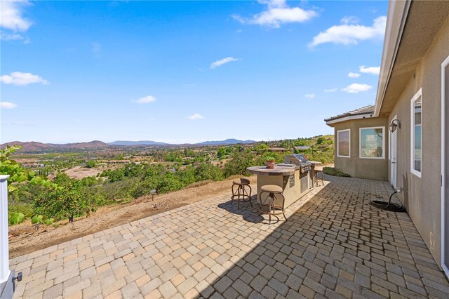 view of patio / terrace with a mountain view and grilling area