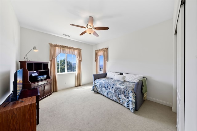 bedroom with ceiling fan and light colored carpet