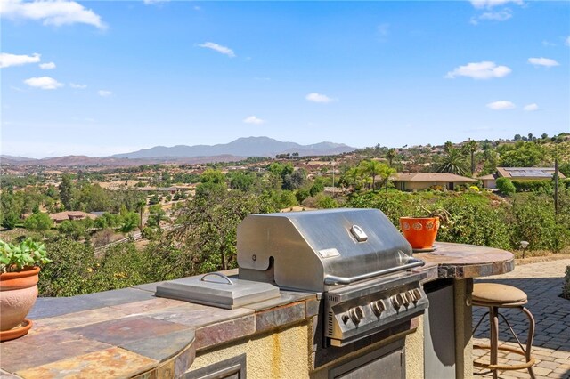 view of patio with area for grilling, a mountain view, and grilling area