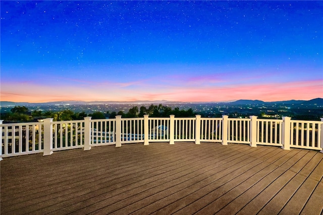 deck at dusk featuring a mountain view